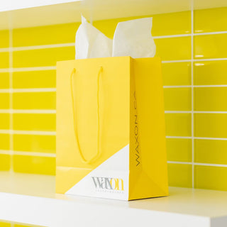Yellow WAXON Laser + Waxbar gift bag on a shelf