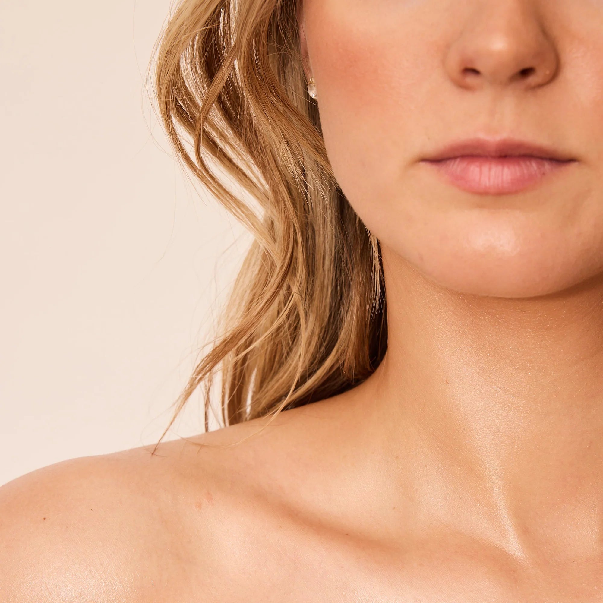 Close-up of a person with blonde hair and a neutral background. Her skin is smooth and free of hair.