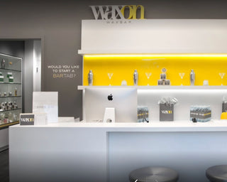 WAXON Laser + Waxbar Burlington location. The image shows the interior view of guest services with a beautifully lit front desk, minimally decorated.