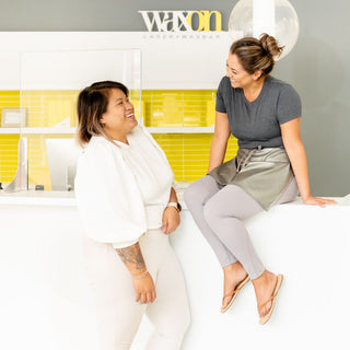 Interior image of WAXON Summerhill location with two staff members smiling and joking together